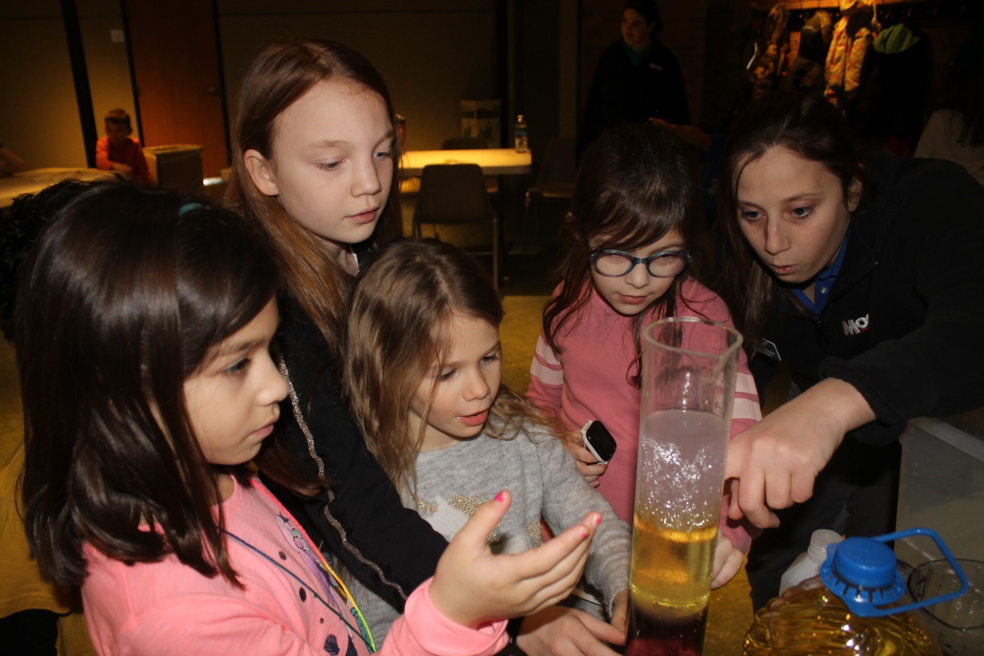 Students in a workshop looking at material in a lab beaker