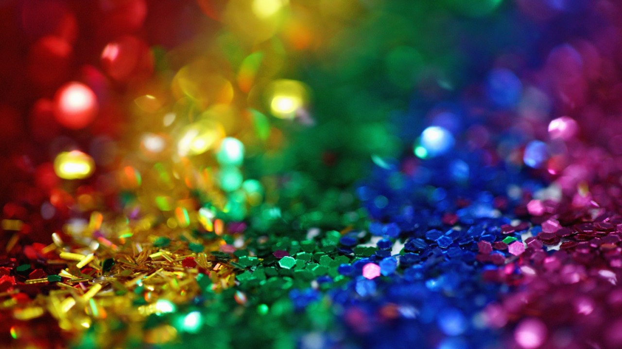 Whimsical and colorful rainbow glitter background.