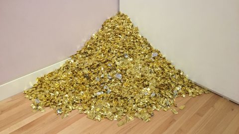 A small mountain of gold-wrapped candies in the corner between two walls
