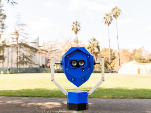 A blue device resembling a periscope, with illustrations of eyes over the eye holes