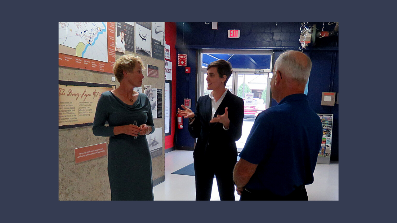 Two museum staff members meeting with a legislator inside a museum