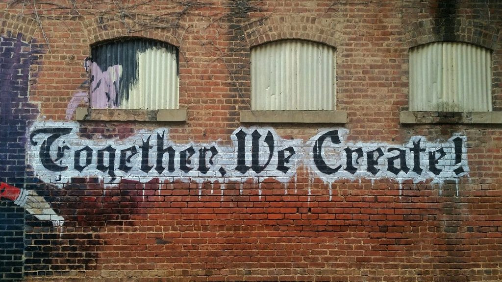 Graffiti reading "Together, we create!"
