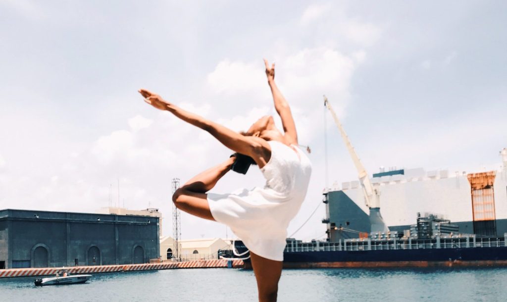 A ballerina posing with arms and legs extended