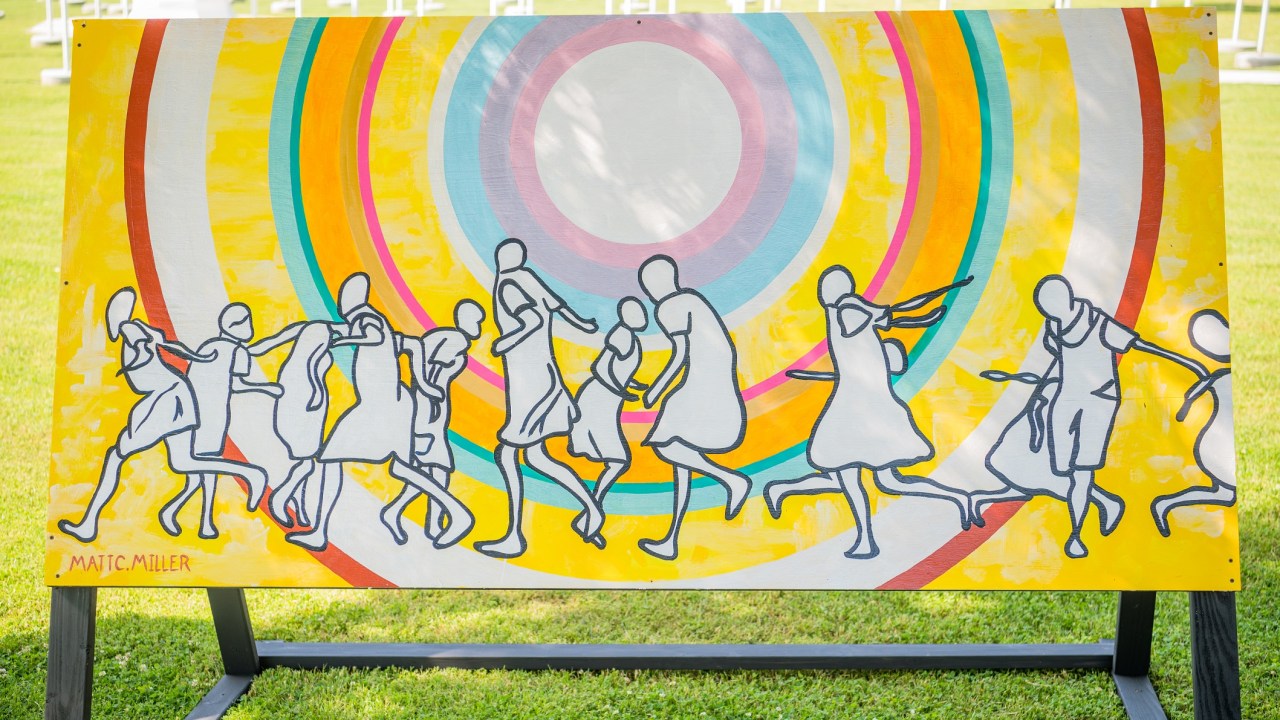 A painting of silhouetted people dancing in front of an abstract spiral shape