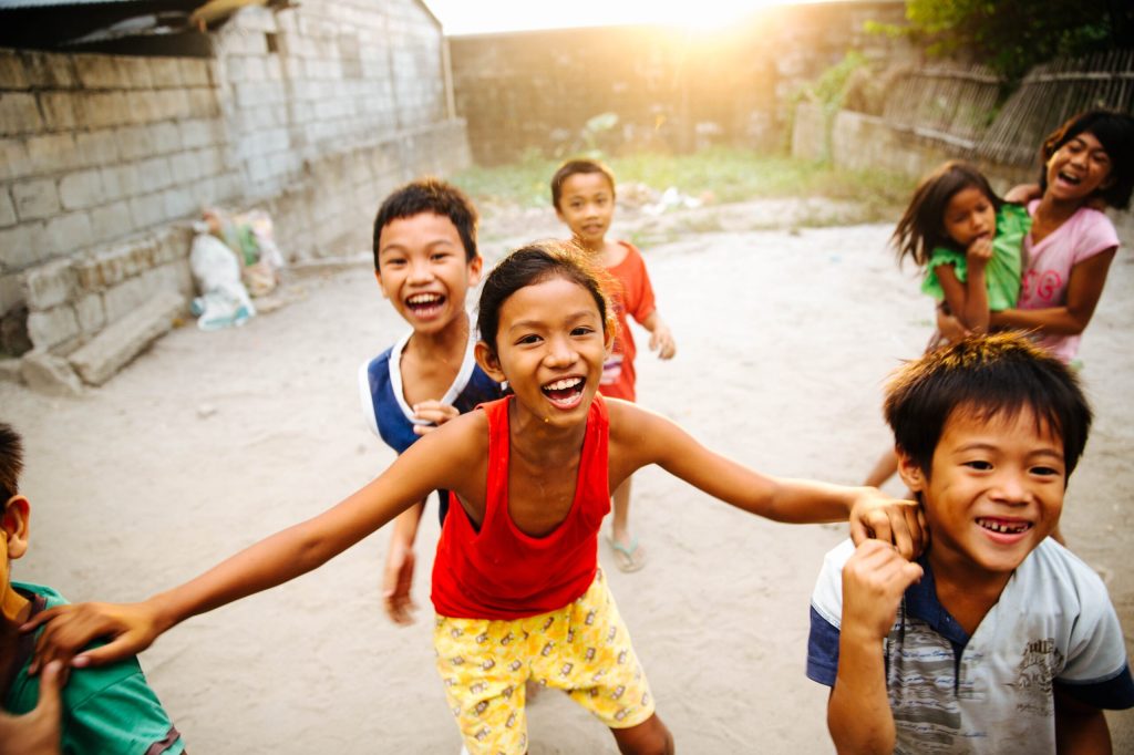 A group of children on a village road laughing and playing