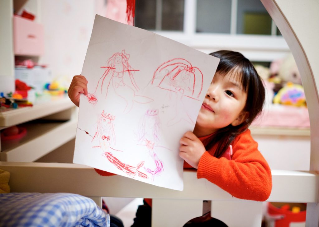 A child holding up a drawing