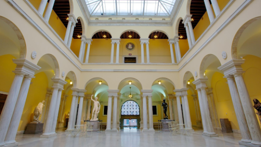 Interior of a museum with yellow walls and sculptures on display