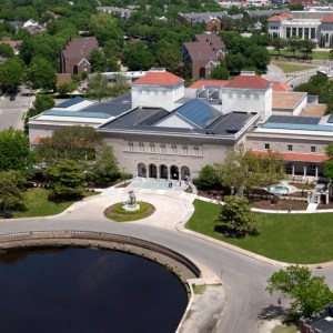 Exterior of a neoclassical museum building with a reflecting pool in front of it