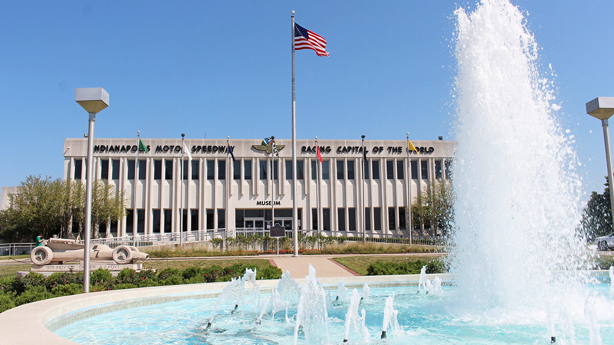 Exterior of a low modernist building behind a running fountain