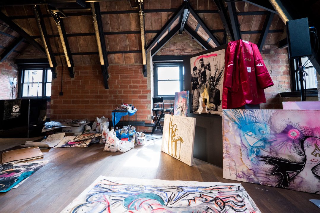 An attic-like space with canvases displayed on the floor