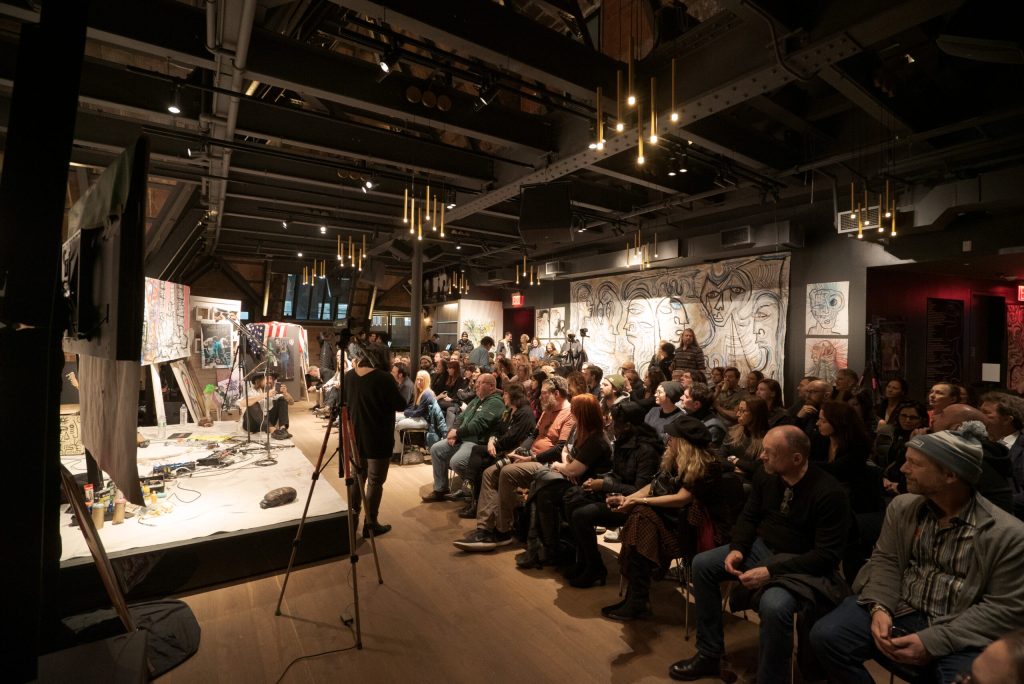 An audience of people watching a speaker