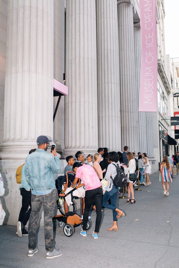 A long line standing outside of the Museum of Ice Cream