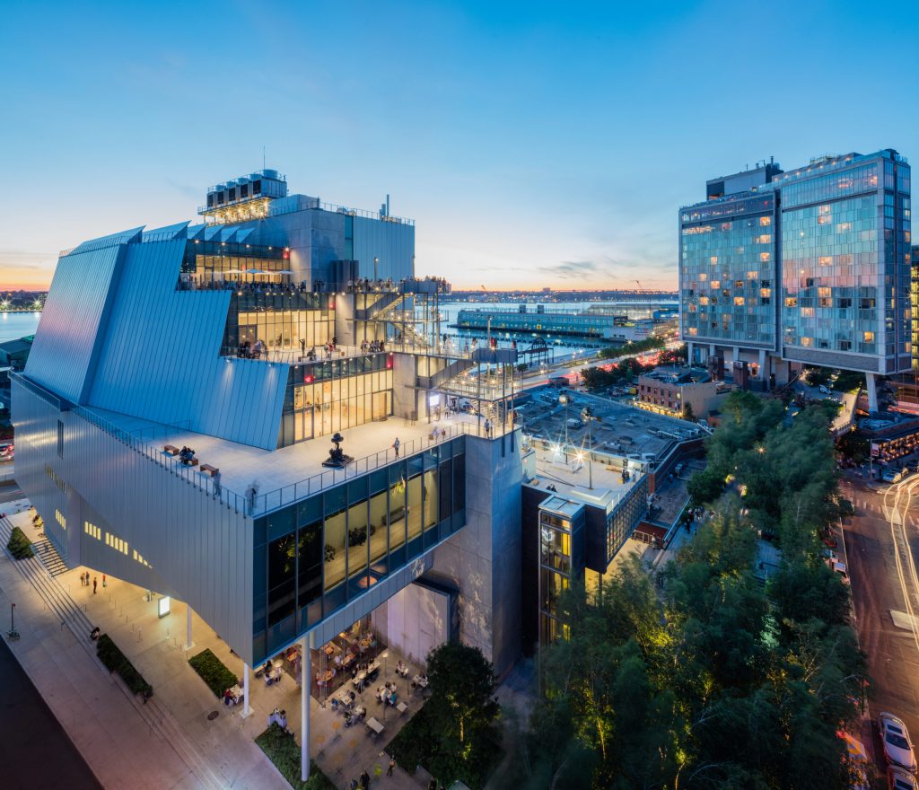 An aerial view of the exterior of the Whitney Museum, with the Hudson River visible in the background