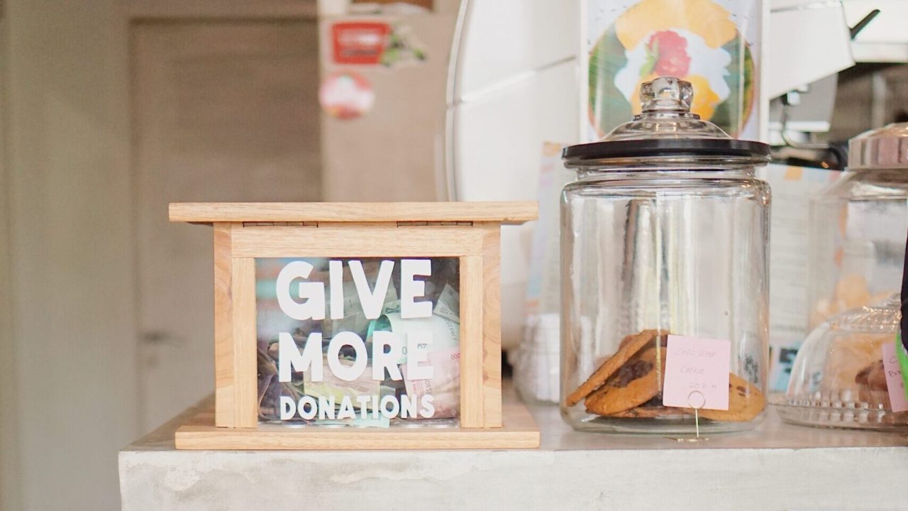 A collection of tip jars with the message "Give More Donations" written on one.