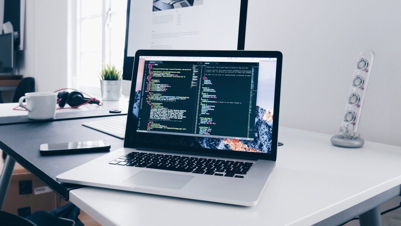 A laptop on a desk open to a coding application