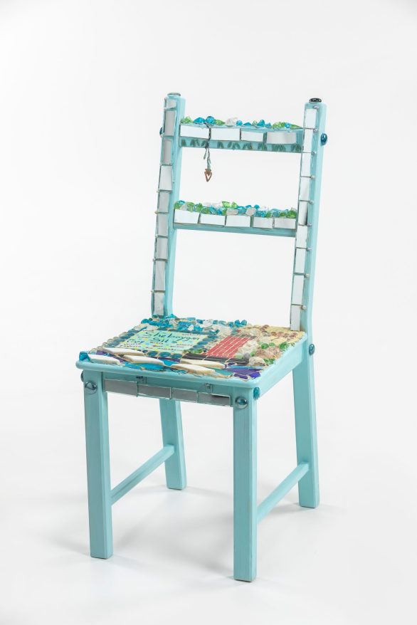 A chair covered in mosaic and gems
