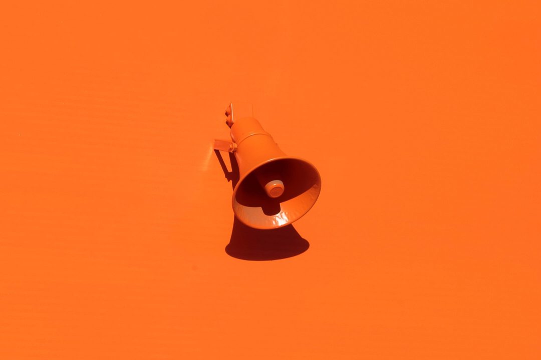 An orange megaphone on an orange background