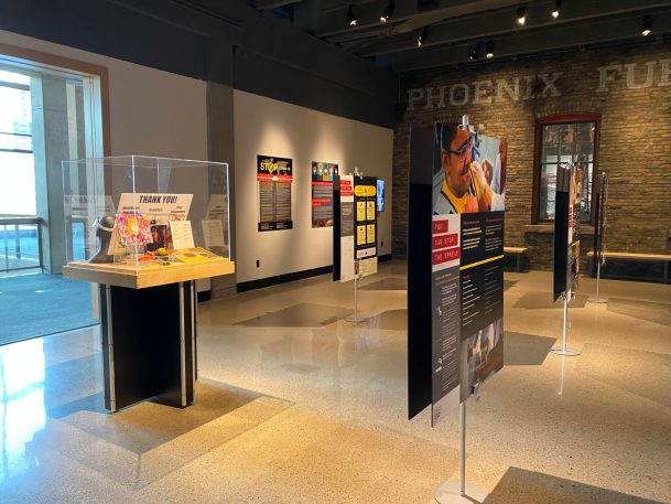 a clear box to the left with artifacts for health care workers. to the right the start of panels displayed on silver easels 