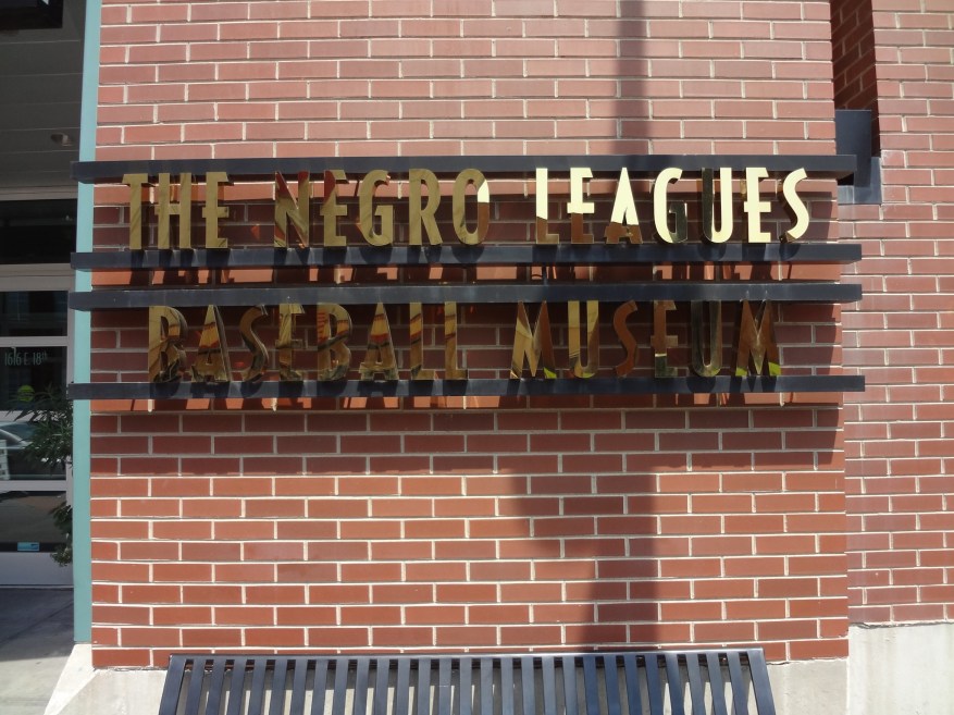 Placard spelling out the name of the Negro Leagues Baseball Museum on a brick wall
