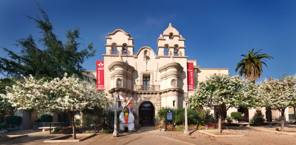 Exterior of an historic building surrounded by trees and a colorful outdoor sculpture