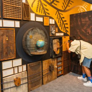 A visitor peering into a peephole on an interactive art installation