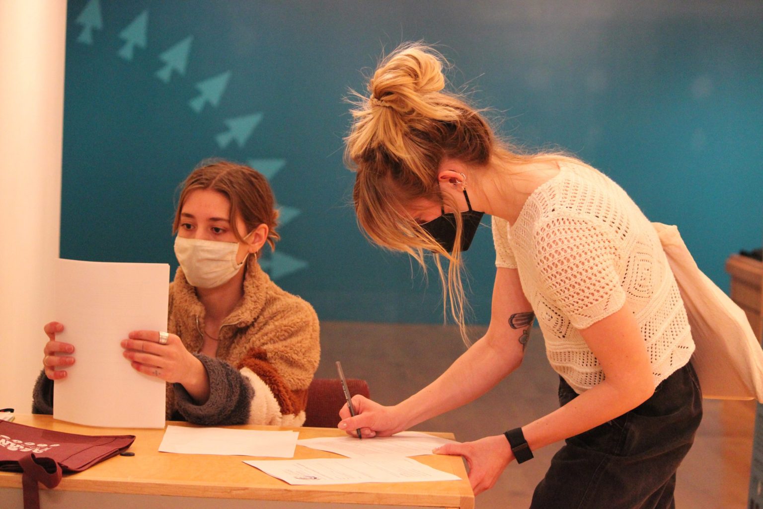 Students sitting at a desk organizing papers