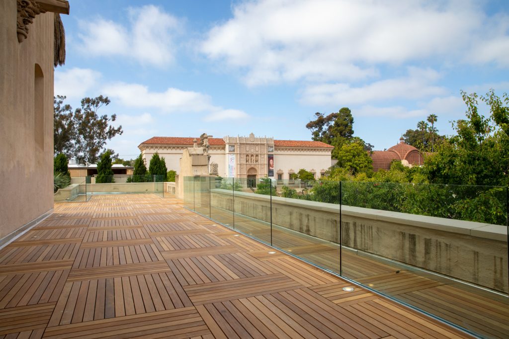 An empty outdoor terrace space with museum buildings and trees visible in the background