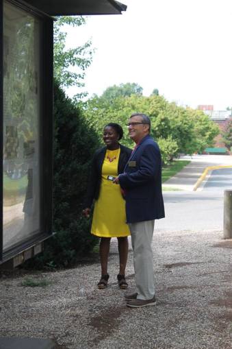 Two people standing outside looking at a historical placard