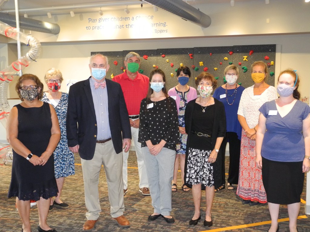 A group portrait of adults in professional clothing wearing masks