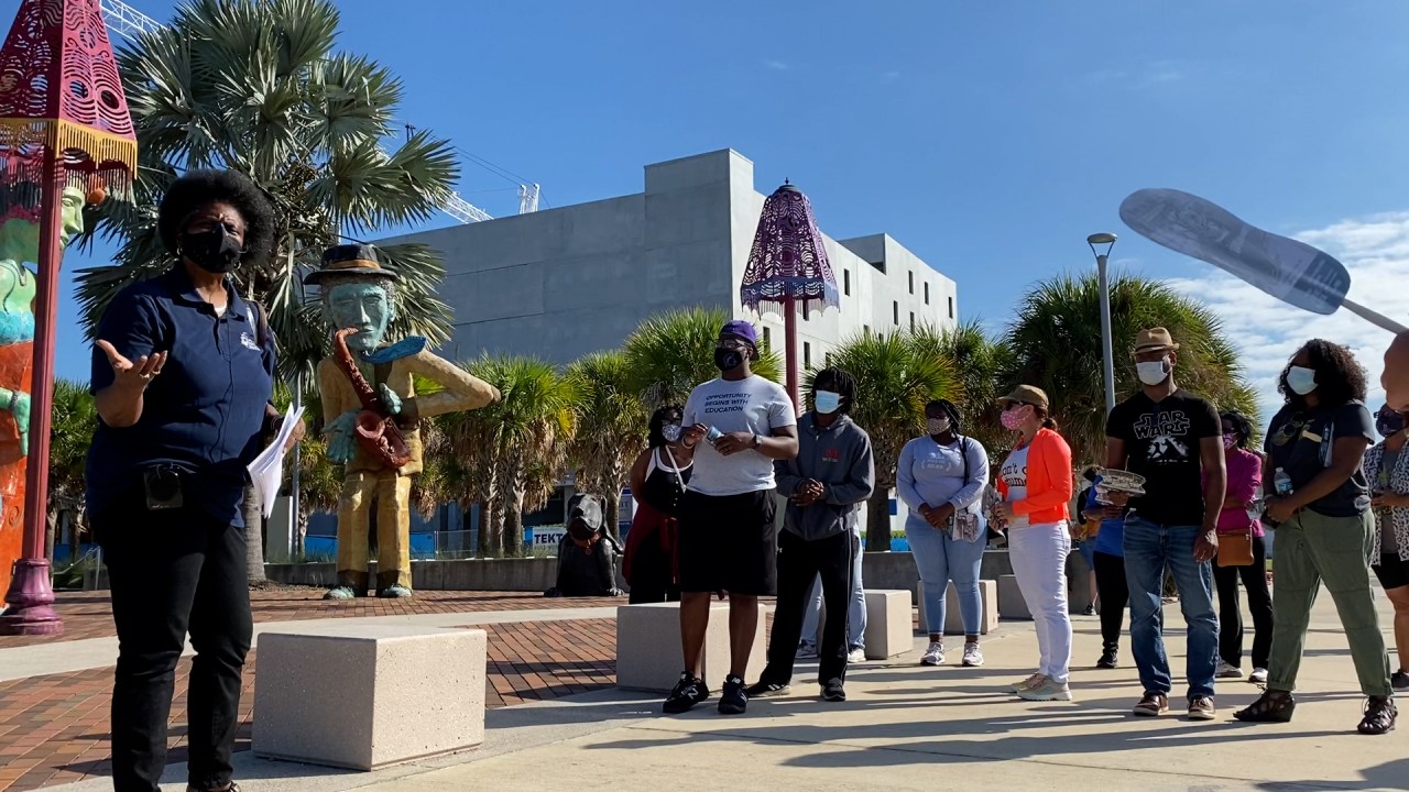 A crowd of people participating in a walking tour on a city street