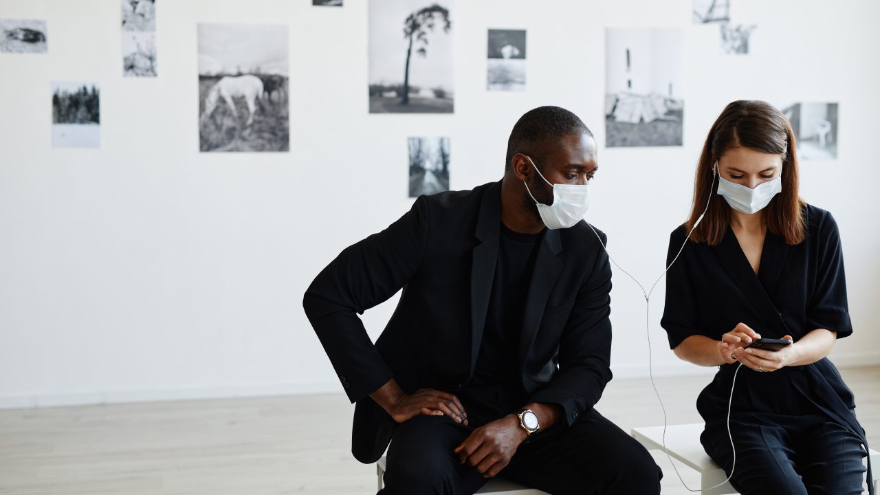 Two people listening to an audio guide in a museum gallery