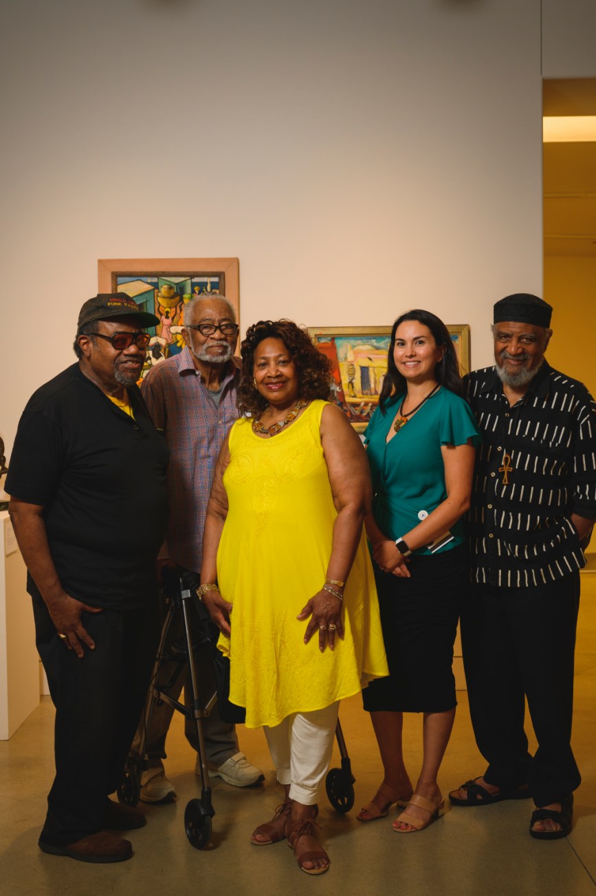 A group of people posing in a museum gallery