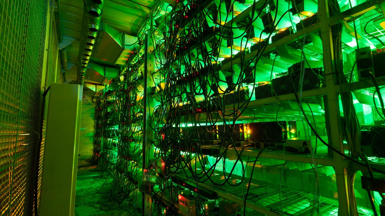 Rank upon rank of computer servers mining Bitcoin at a cryptocurrency "farm." Image credit: artiemedvedev.