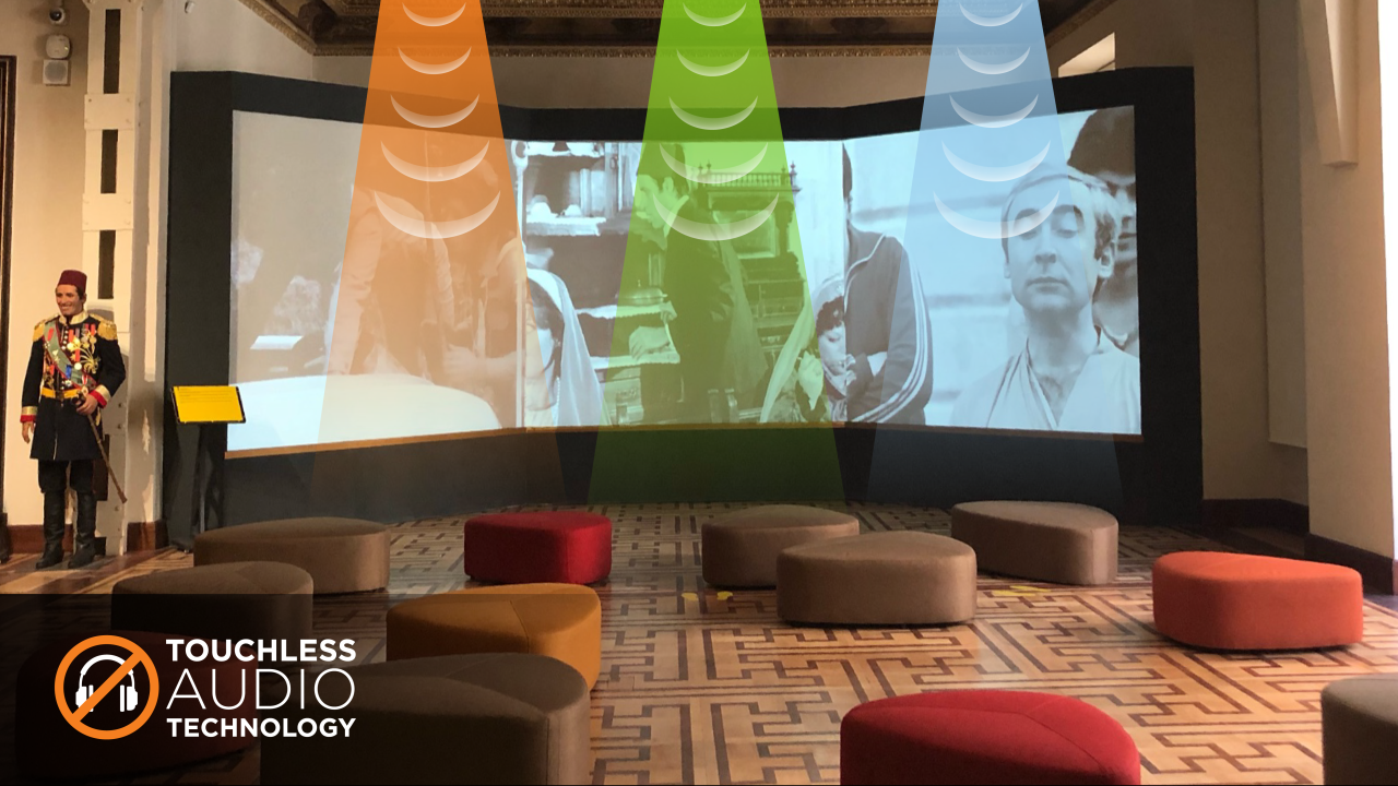 A theater playing a video with superimposed renderings of sound beams emitting from three speakers above the screen
