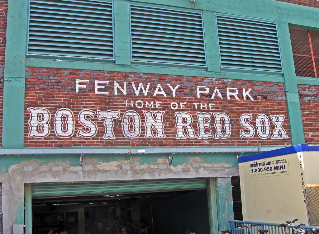 Sign at the entrance to a sporting arena reading "Fenway Park / Home of the Boston Red Sox"