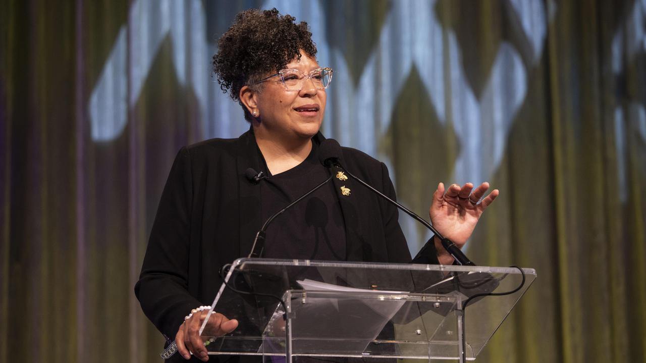 Sandra Jackson-Dumont standing at a podium and gesturing with her hands