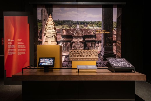 A museum display with digital screens next to physical artifacts
