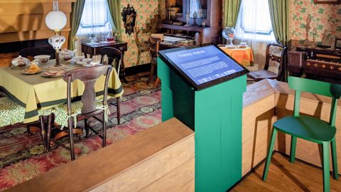 A historic house interior with a touchscreen panel in front of a display