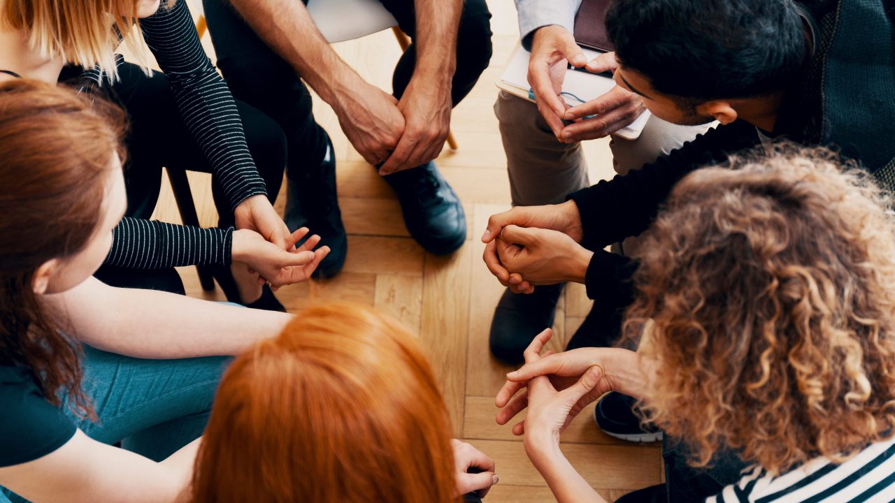 A group of people sitting in a circle photographed from above