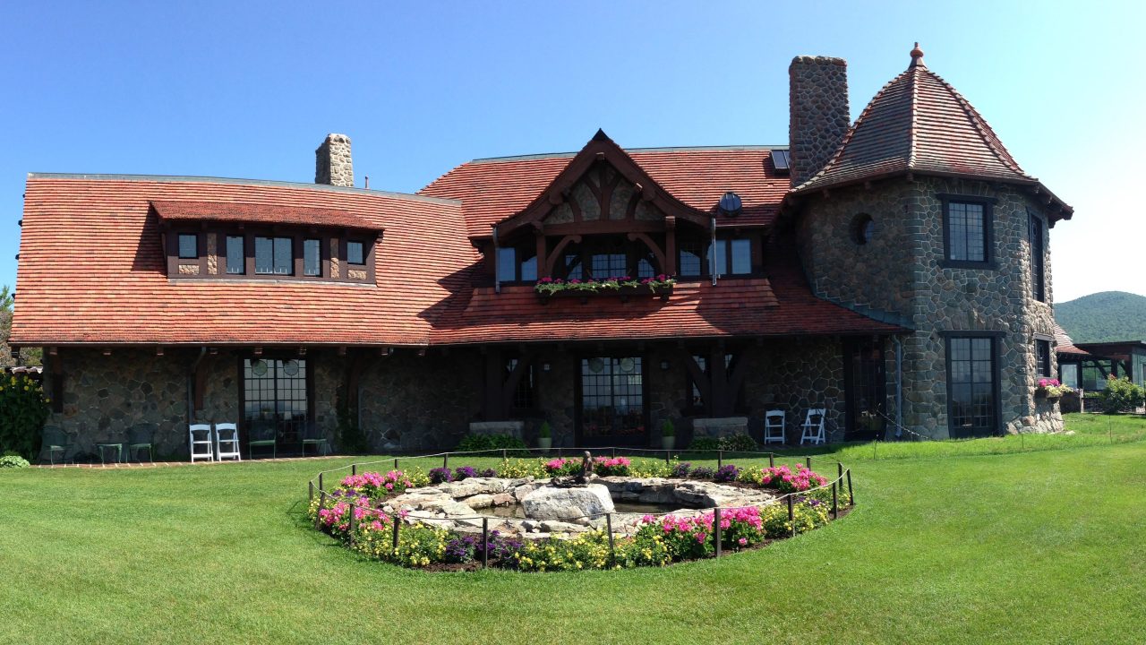 A historic mansion with mountains visible in the background