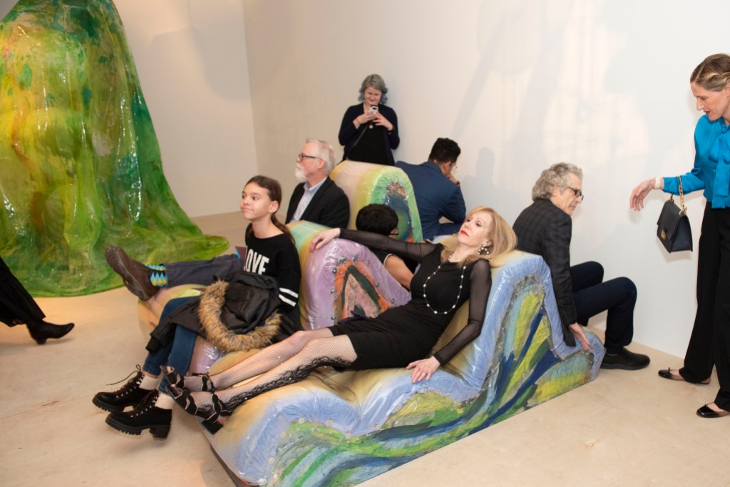 People sitting on a reclining sofa design in a gallery space