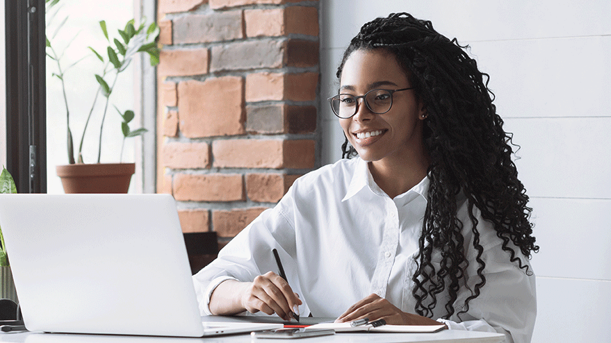 person smiling in front of a laptop