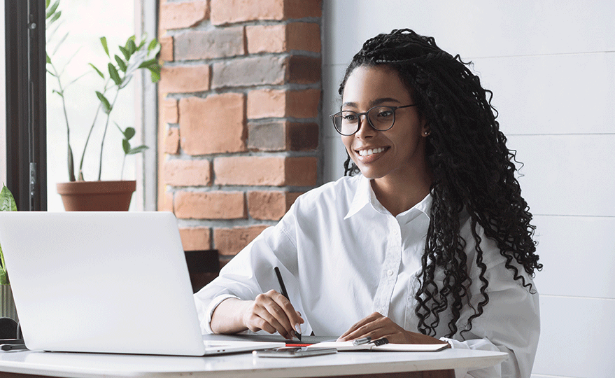 a person smiling at a laptop