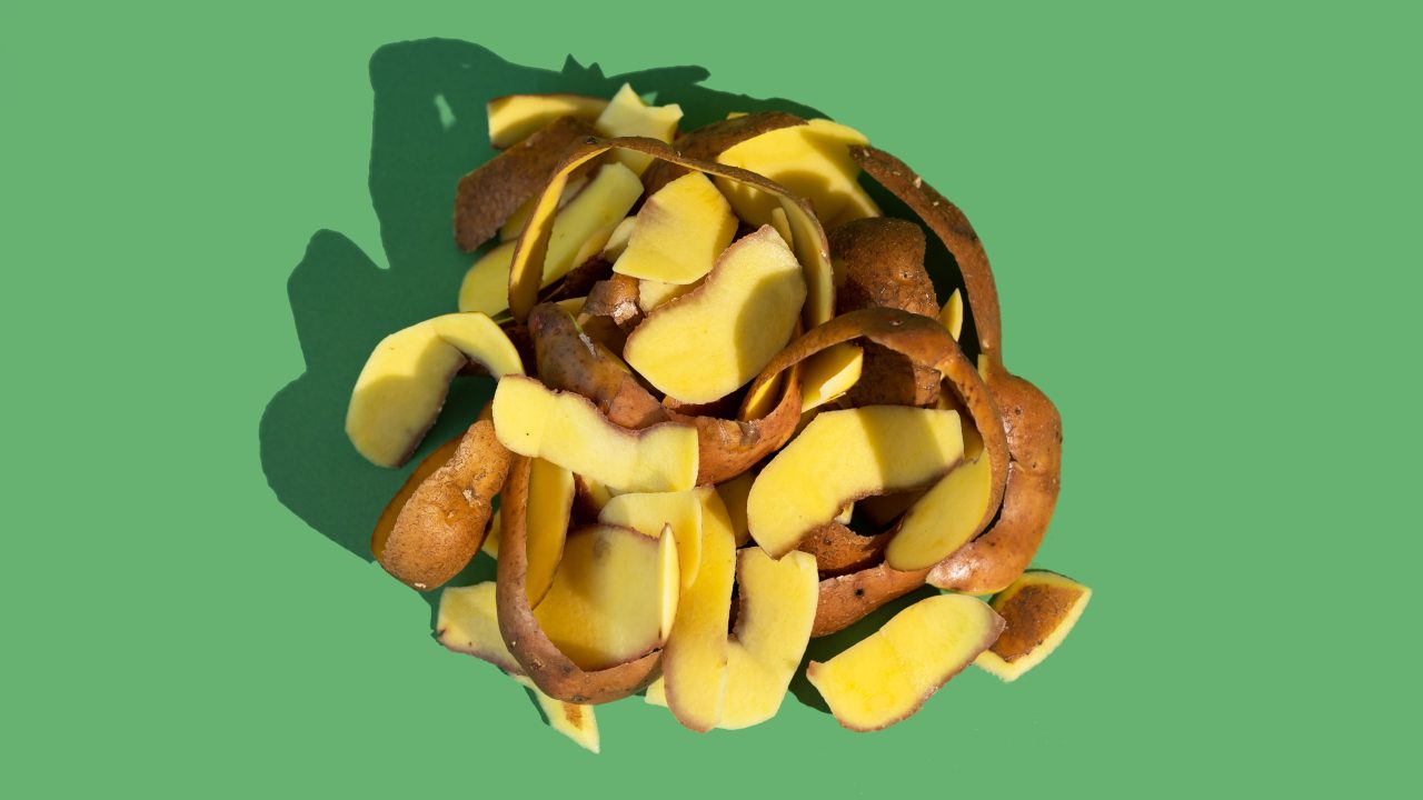 A pile of potato peels on a green background