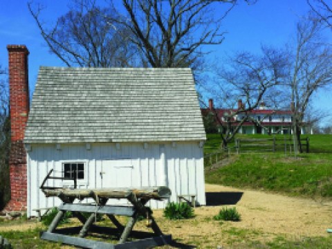 A small white building is shown in the foreground with with the mansion off in the distance.