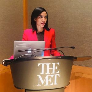 Irma Cedeno Verdon standing at a podium with the logo of The Met on it