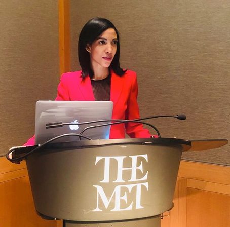 Irma Cedeno Verdon standing at a podium with the logo of The Met on it