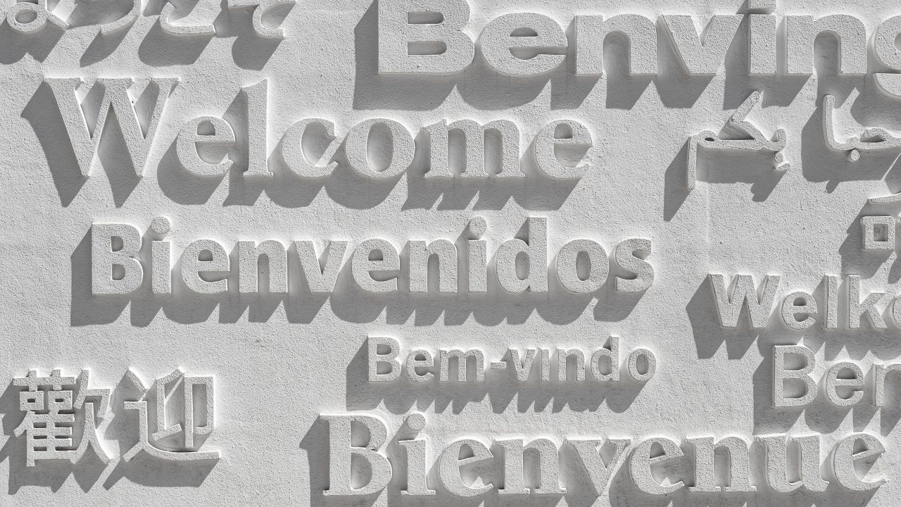 An engraved sign with the word welcome written in multiple languages