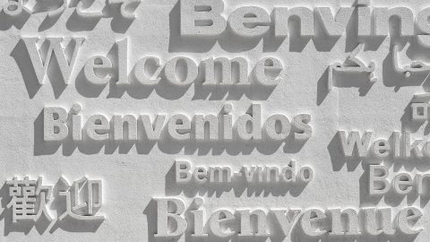 An engraved sign with the word welcome written in multiple languages