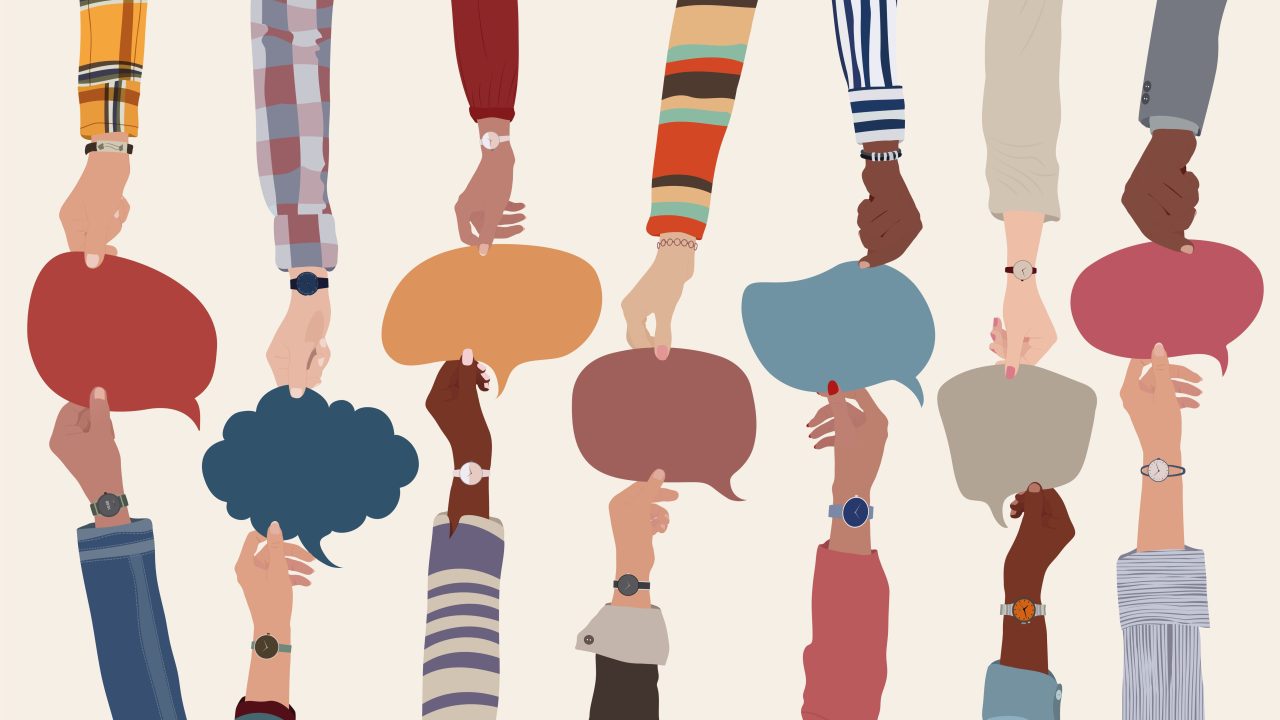 An illustration of people with a range of different skin colors holding speech bubble symbols between them.